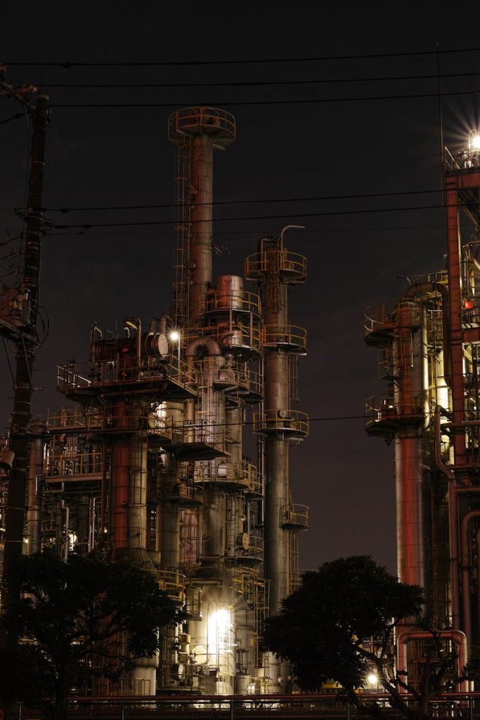Night view of a brightly lit industrial facility showcasing intricate steel structures and machinery.